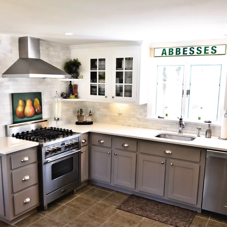 Kitchen with grey shaker cabinets, marble backsplash and professional range