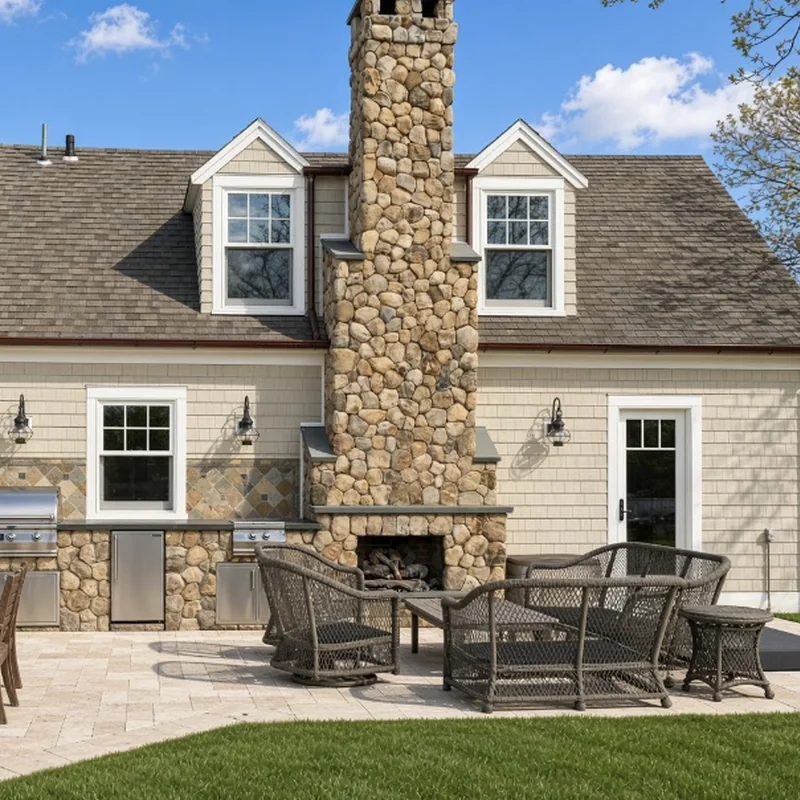 Bluestone patio with a fieldstone outdoor fireplace and built-in grill